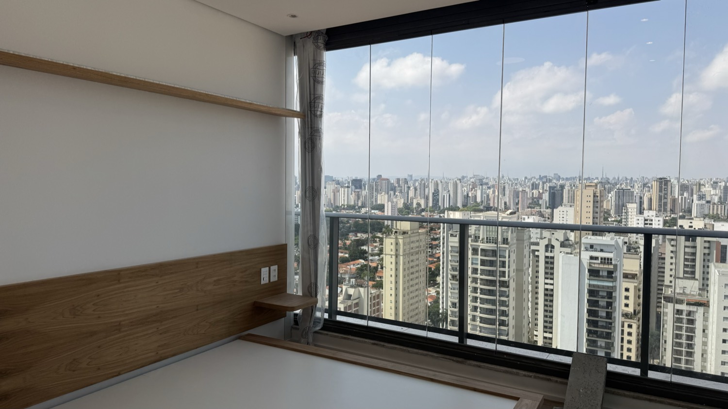 Cobertura Brooklin — living com janela panorâmica e vista para São Paulo